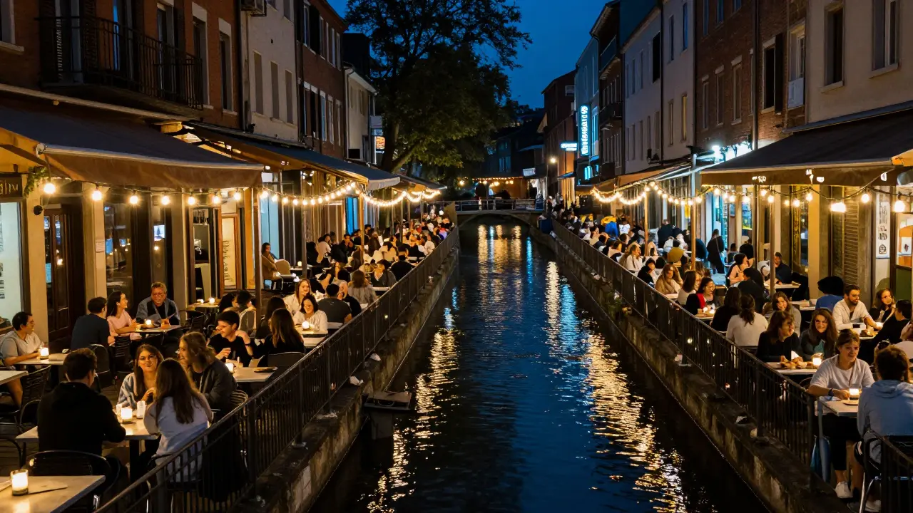 Outdoor canal-side bars lit by strings of lights at night.